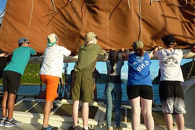 A group works together sailing in the Caribbean